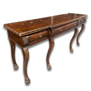 Used 80" Ornate Traditional Wood Sofa Table with Three Drawers This grand traditional sofa table features intricate wood detailing, three spacious drawers, and carved lion paw feet for a distinctive statement piece. Ornate traditional wood craftsmanship Three functional storage drawers Decorative lion paw feet  Dimensions: 80"W x 24"D x 36"H Ideal for executive suites, reception areas, or formal office lounges.