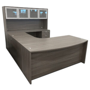 Used 71"W Grey U-Shape Bowfront Desk with Glass Door Hutch - RH Executive U-shape desk set finished in grey laminate with a bowfront design for client-facing meetings. Includes a glass door hutch for added storage and display. U-shape configuration with bowfront desk (1) File/File Pedestal & (1) Box/Box/File pedestal Right-hand return Overhead hutch with glass doors for storage and display Dimensions: Desk: 71"W x 48"D x 30"H Bridge: 30"W x 24"D x 30"H Credenza: 71"W x 24"D x 30"H Ideal for executive offices, private offices, and professional workspaces.