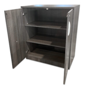 A practical low storage cabinet designed for secure organization of office supplies, with a clean, modern grey woodgrain laminate finish and adjustable shelves for flexible storage. Grey woodgrain laminate finish Locking double doors Two adjustable shelves Silver curved pull handles Sturdy construction for commercial use Dimensions: 36½″W x 22″D x 42″H Perfect for offices, conference rooms, and shared workspaces