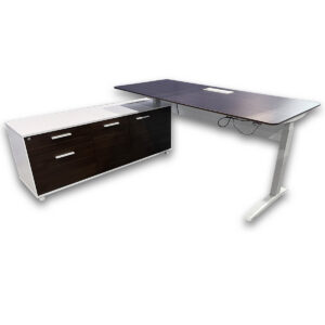 Used 71"W Two Tone Height Adjustable Desk W/ Lower Storage Cabinet - White / Walnut  This used height adjustable workstation pairs a spacious walnut top with an integrated storage cabinet, offering a practical solution for everyday office work. Height adjustable desk surface Integrated power cutout on desktop Walnut finish work surface Storage cabinet with white frame and walnut drawers Cabinet provides concealed storage and surface support Dimensions: Desk: 71W x 31 1/2D Cabinet: 63W x 19D x 24 3/4H Perfect for private offices, executive suites, and collaborative workspaces.